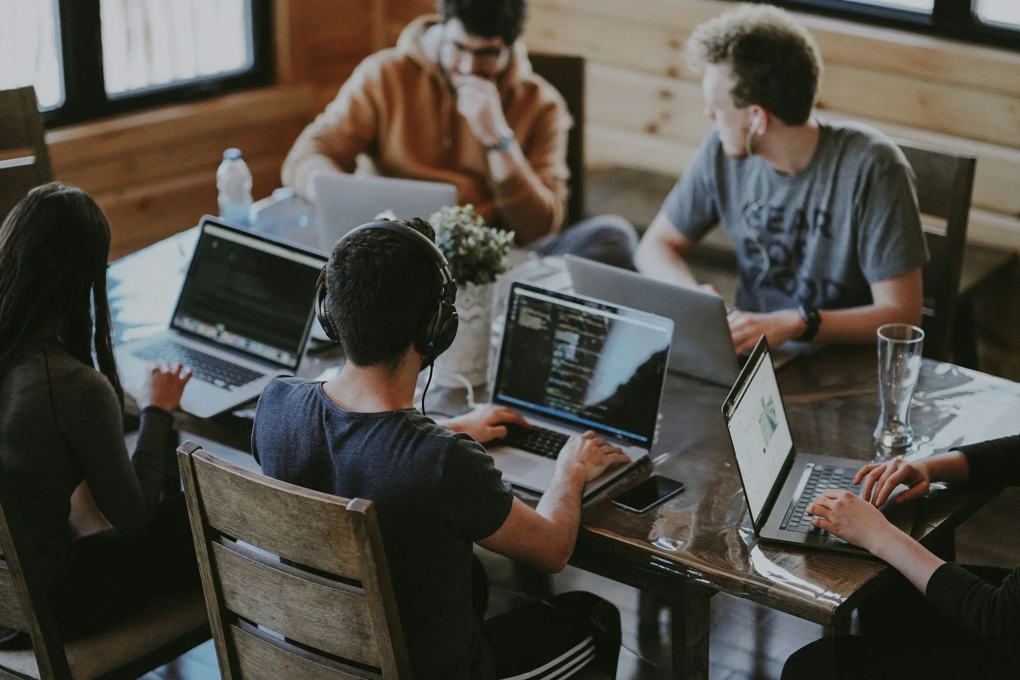 IT professionals collaborating on laptops in a modern office.